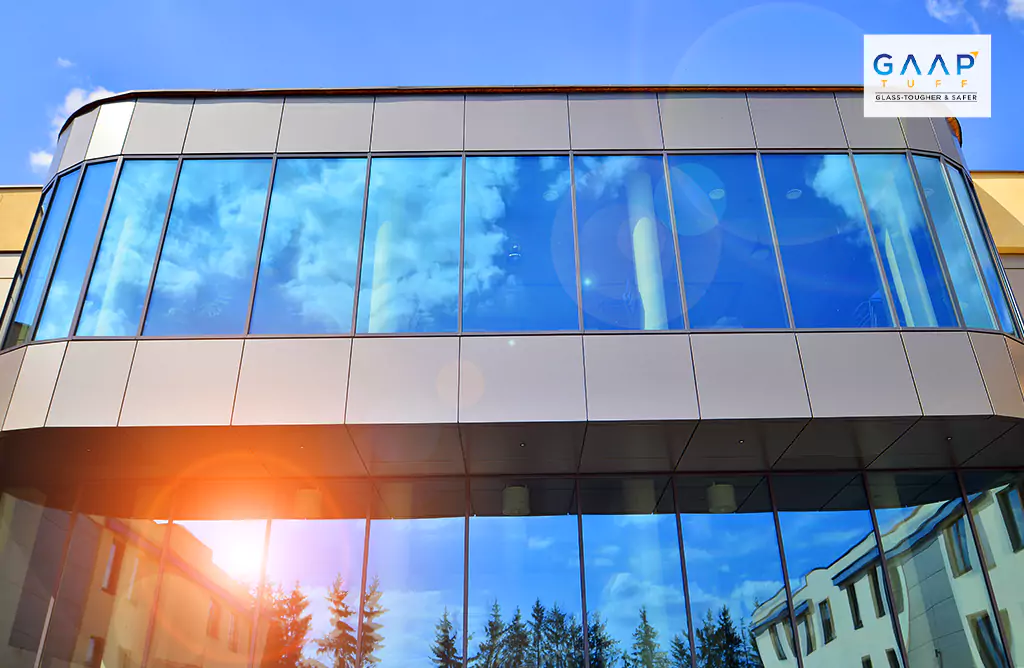 Contemporary Glass Building Reflects the Blue Sky and Clouds